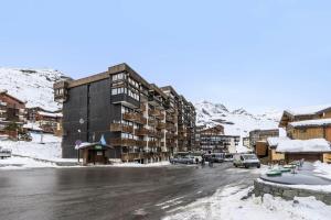 a parking lot with a building in the snow at Résidence Neves - VAL THORENS location: Studio ensoleillé pour 4 personnes dans un quartier animé (LES NEVES) MAE-9081 in Val Thorens
