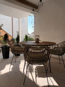a table and chairs in a room with a window at Apartman Natalija in Privlaka