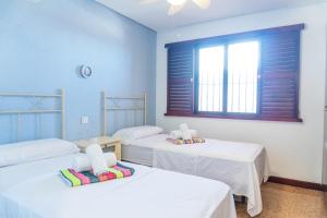 a room with three beds and a window at Nogalera apartamento 3 dormitorio con piscina in Torremolinos