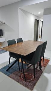 Una mesa y sillas de madera en una habitación. en Homestay T'Sya, Batu Buruk, en Kuala Terengganu 3 fotos más