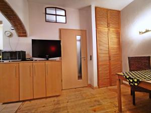 a living room with a flat screen tv and a table at Studio Brennerei Haselberg in Wriezen +8 photos