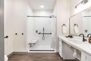 Un baño blanco con ducha y lavabo. en Dynamic Stay Connected Comfort Steps from Atrium, en Macon