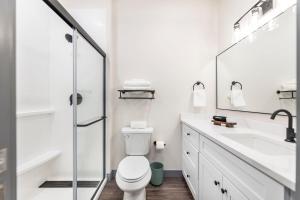 Un baño blanco con inodoro y lavabo. en Dynamic Stay Connected Comfort Steps from Atrium, en Macon