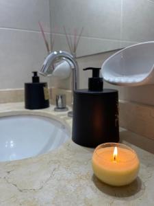 eine Kerze auf der Badezimmertheke mit einer Badewanne in der Unterkunft Inas Urquiza I in Santa Rosa