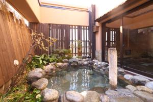 a small pool of water in front of a building at Dormy Inn Matsumoto in Matsumoto