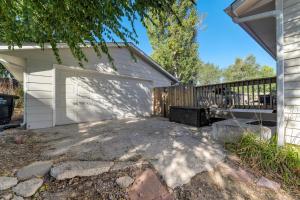 a garage with a white garage door next to a house at Cheerful Chalet Centrally Located w BBQ Pit in Colorado Springs