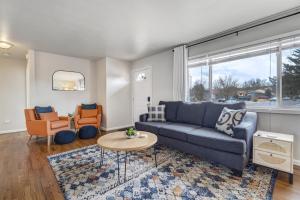 a living room with a blue couch and a table at Cheerful Chalet Centrally Located w BBQ Pit in Colorado Springs