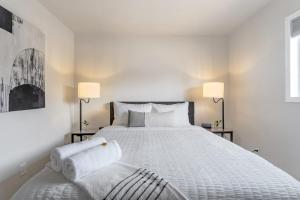 a bedroom with a large white bed with two lamps at Cheerful Chalet Centrally Located w BBQ Pit in Colorado Springs +37 photos
