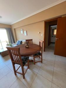 einen Holztisch und Stühle in einem Zimmer mit einem Bett in der Unterkunft Inas Urquiza I in Santa Rosa