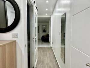 a hallway leading to a living room with a mirror at Verb Studio - North London Enfield Self Catering Holiday - work accommodation in Enfield