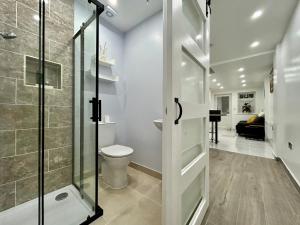 a bathroom with a toilet and a glass shower door at Verb Studio - North London Enfield Self Catering Holiday - work accommodation in Enfield