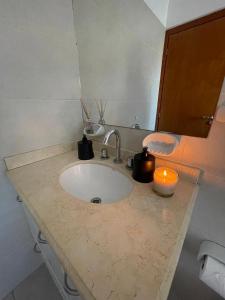 eine Badezimmertheke mit einem Waschbecken und einer Kerze in der Unterkunft Inas Urquiza I in Santa Rosa + 12 Fotos