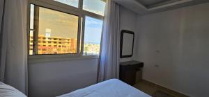 Un dormitorio con una ventana con vista a un edificio. en Elhambra First Avenue, en Hurghada 19 fotos más
