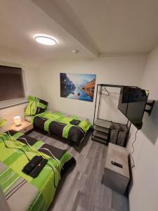 ein Zimmer mit zwei Betten und einem Flachbildfernseher in der Unterkunft GRooms in Gemmrigheim