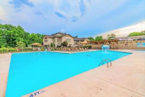 a large swimming pool with blue water in front of a house at Pointe Royale 52-7, Golf, Indoor and Outdoor Pools in Branson