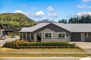a house on the side of a road with a mountain at Mountain View - 2 Bedroom House in Queenstown