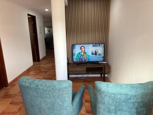 two chairs in front of a television in a living room at Villa do Monte Sunset in Porto Moniz