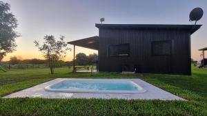 a hot tub in the grass in front of a house at Almada - Casas de Campo in Baradero