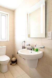 a bathroom with a sink and a toilet and a mirror at Luxury 3 Bedroom Apartment in Sliema - Walk to Beach & Dining in Sliema +24 photos