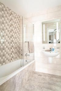 a bathroom with a tub and a sink and a shower at Luxury 3 Bedroom Apartment in Sliema - Walk to Beach & Dining in Sliema