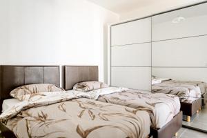two beds in a room with white walls at Luxury 3 Bedroom Apartment in Sliema - Walk to Beach & Dining in Sliema