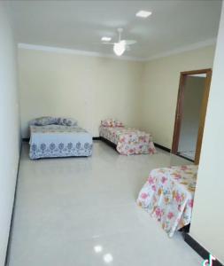 una habitación con dos camas y un espejo en Hostel Tia Ró Quartos Feminino e Masculino Lugar de paz, en Governador Valadares