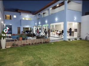 un gran edificio con gente sentada en un patio en Hostel Tia Ró Quartos Feminino e Masculino Lugar de paz, en Governador Valadares 5 fotos más