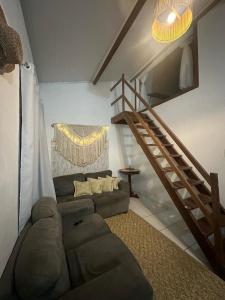 a living room with a couch and a staircase at Casa de Mainha Arraial in Arraial d'Ajuda +16 photos