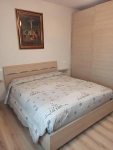 a bed in a bedroom with a picture on the wall at Mary House in Ossimo