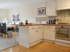 a kitchen with white cabinets and a table with chairs at Rolton House in Ambleside