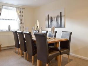 a dining room with a wooden table and black chairs at Rolton House in Ambleside