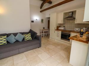 a living room with a couch and a kitchen at Christon Well Cottage in Alnwick +13 photos