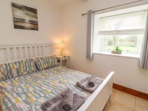 a bedroom with a bed with towels on it at Christon Well Cottage in Alnwick