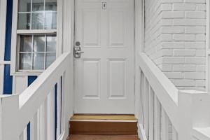 une porte blanche sur une maison en briques blanches dans l'établissement Cabana Beach #4 Condo Steps from the Beach, à Myrtle Beach