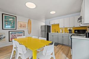 une cuisine avec une table jaune et des chaises blanches dans l'établissement Cabana Beach #4 Condo Steps from the Beach, à Myrtle Beach