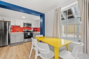 une cuisine avec une table jaune et des chaises blanches dans l'établissement Cabana Beach #3 Condo Steps from the Beach, à Myrtle Beach