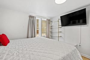 - une chambre blanche avec un grand lit et une télévision dans l'établissement Cabana Beach #3 Condo Steps from the Beach, à Myrtle Beach