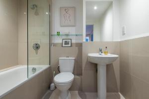a bathroom with a toilet and a sink at Battersea Power Station Apartment in London
