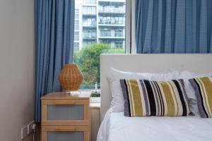 a bedroom with a white bed and a window at Battersea Power Station Apartment in London