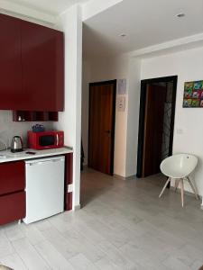 a kitchen with a red microwave and a table at ApartHotel Crescenzago House in Milan