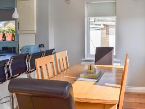 a dining room with a wooden table and chairs at Grays Cottage in Sewerby