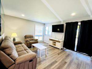 a living room with a couch and a flat screen tv at Bay tree lovely one bedroom condo in Little River