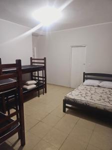 モジ・ダス・クルーゼスにあるRecanto Cauê & Mariaのベッド1台、テーブル、ベッド1台、デスクが備わる客室です。 +6枚の写真