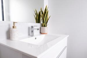 ein weißes Waschbecken mit zwei Pflanzen drauf in der Unterkunft Brand New 2BR Home in City in Christchurch