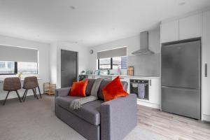 ein Wohnzimmer mit Couch und Küche in der Unterkunft Brand New 2BR Home in City in Christchurch