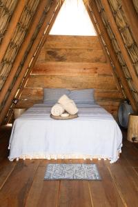 a bed with two towels on it in a attic at Hidden Port TTipis Vista Carrizalillo in Puerto Escondido