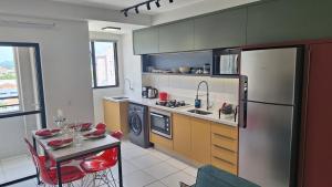 a kitchen with a stainless steel refrigerator and a table at Apto, Moderno - perto da WEG in Jaraguá do Sul