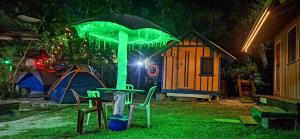 蜜岛克洛铎露营旅馆的一张桌子、一把伞、两把椅子和一个帐篷