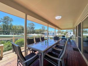 a dining room with a table and chairs on a deck at Burrumundi - 100M To Beach - Great Water Views - Deck - Air Con - WiFi - Pool Table in Burrum Heads