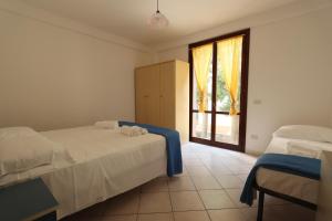 a bedroom with two beds and a window at ModernShore - Oltremare in Tortoreto Lido